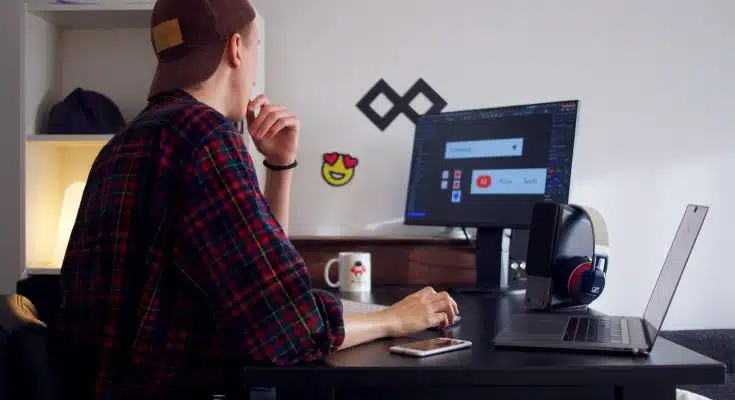 man sitting near table using computer